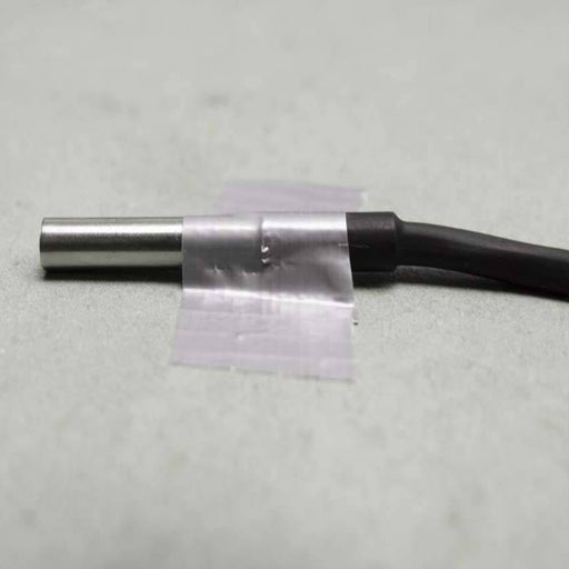 Tramex Contact Temperature Probe - CTP Image of a Tramex contact temperature probe taped to a concrete floor, showcasing its design and application for measuring surface temperature.