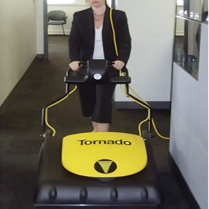 Operator pushing the Tornado CK 3030 wide-area vacuum across a carpeted floor