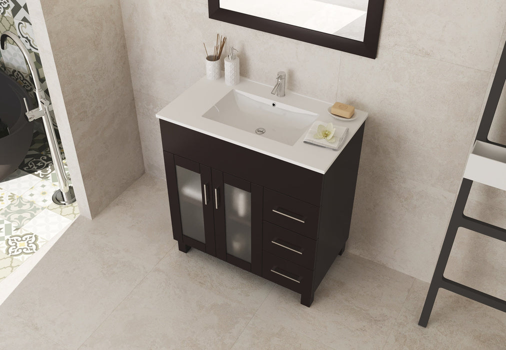 Dark brown vanity with white countertop and sink in a bathroom.