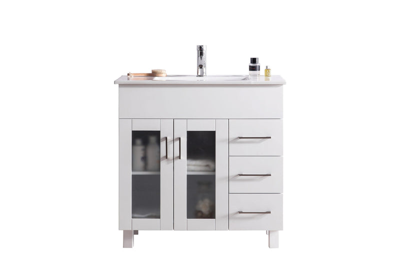 White bathroom vanity with glass doors and chrome hardware.