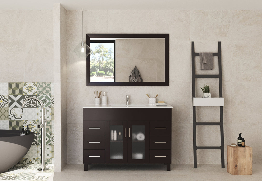 Bathroom interior with a dark wood vanity, marble countertop, and a matching framed mirror. A modern-style ladder stands to the right.