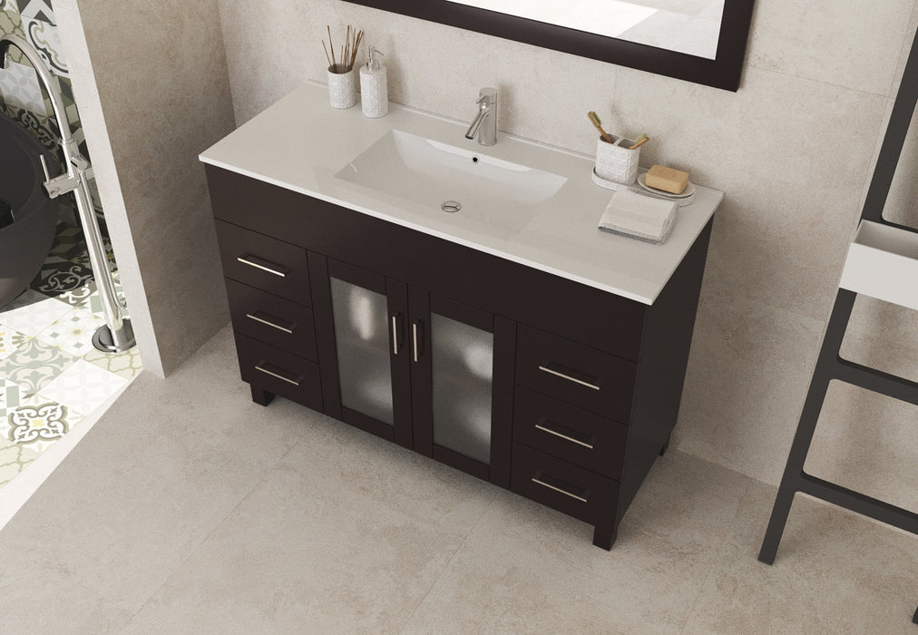 Bathroom vanity with dark cabinet, light countertop, and sink.