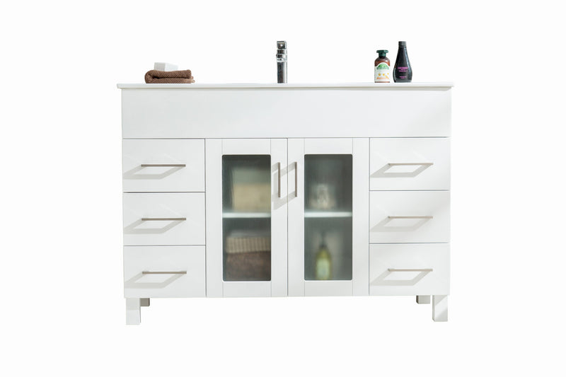 White bathroom vanity with drawers and frosted glass doors.
