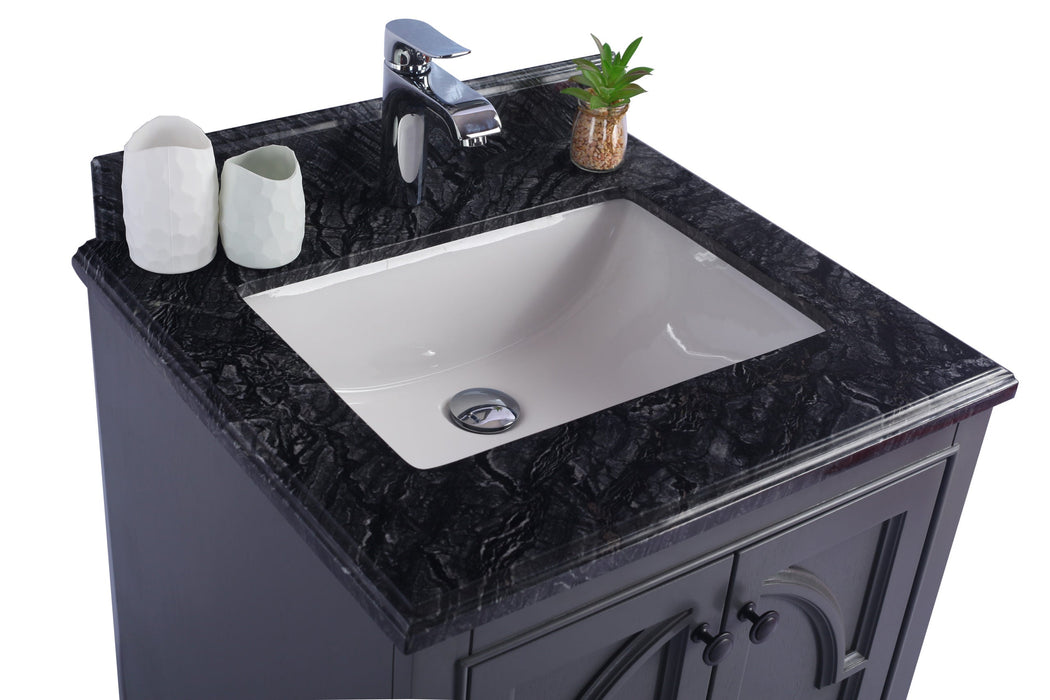 Bathroom vanity with a black granite countertop, white basin, chrome faucet, toothbrush holder, and a small plant in a glass jar.