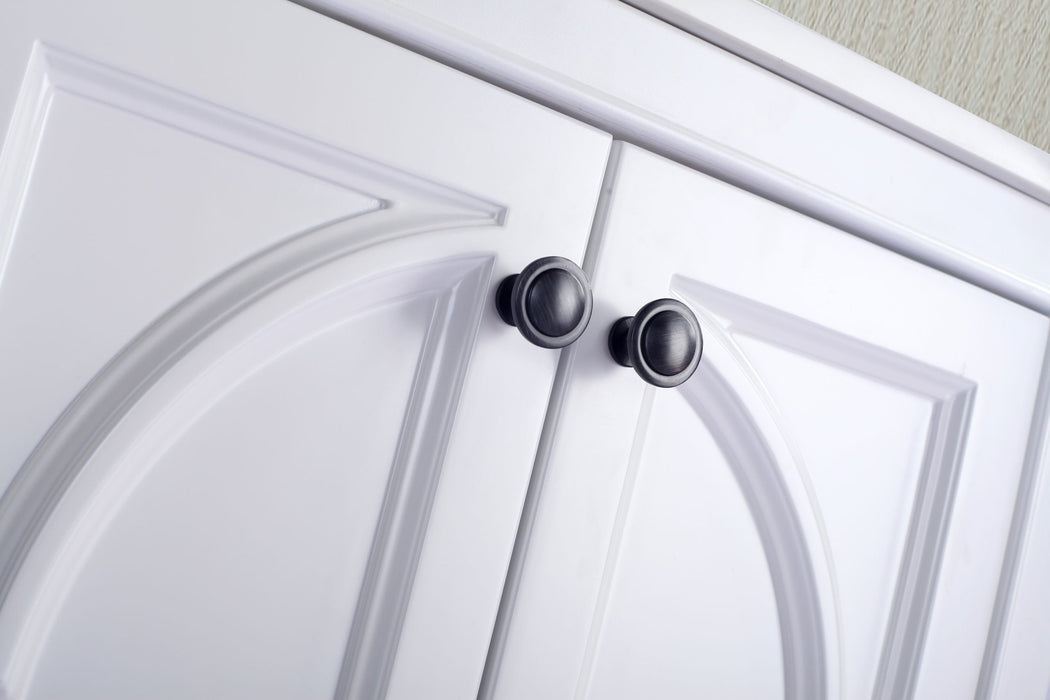 Close-up of white cabinet doors with dark metal knobs.