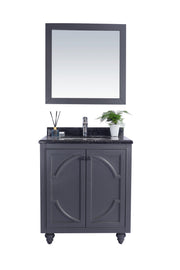 Bathroom vanity with mirror, gray cabinet, black countertop, and silver faucet.