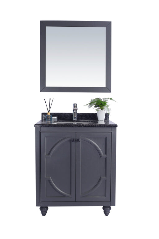 Bathroom vanity with mirror, gray cabinet, black countertop, and silver faucet.