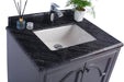 Bathroom vanity with a black marbled countertop, white sink, chrome faucet, and gray cabinet.