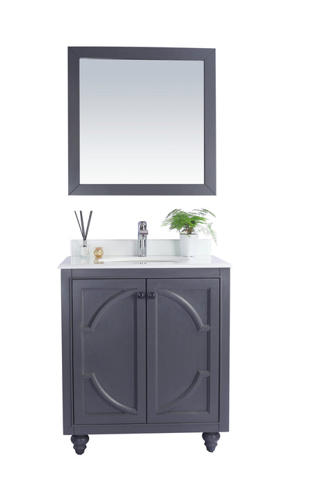 Gray bathroom vanity with white countertop and matching framed mirror.