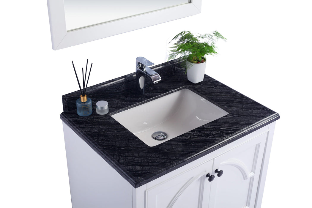 Bathroom vanity with black countertop and white cabinet.