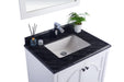 Bathroom vanity with black countertop and white cabinet.