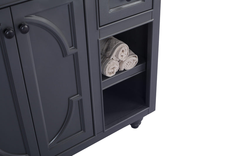 Close-up of a gray vanity with rolled towels in the open shelving.