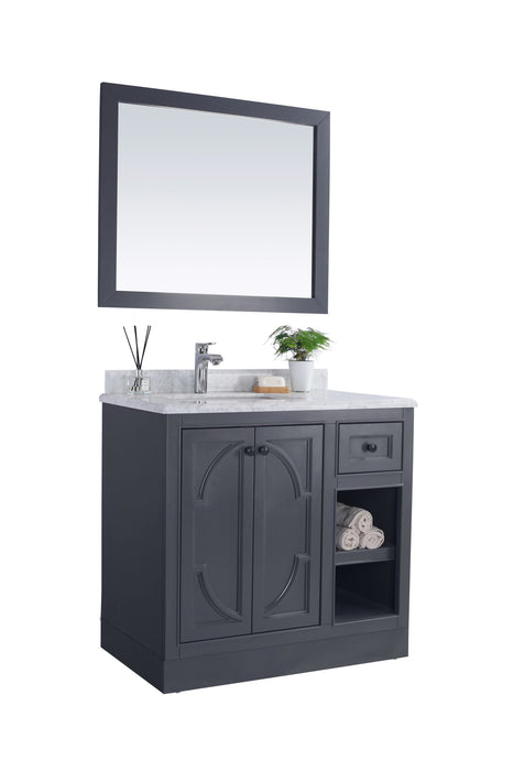 Gray bathroom vanity with marble top and matching framed mirror.