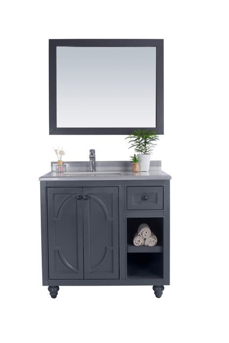 Gray bathroom vanity with mirror and decor.
