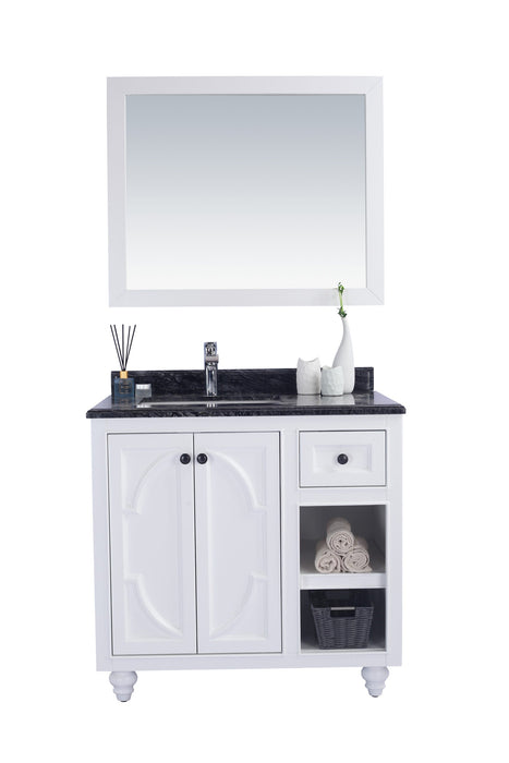 A white bathroom vanity with a black countertop and a matching mirror.