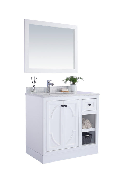 White bathroom vanity with a marble top and a matching framed mirror above.