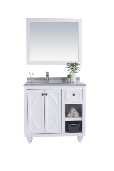 White bathroom vanity with mirror, silver faucet, and gray countertop.