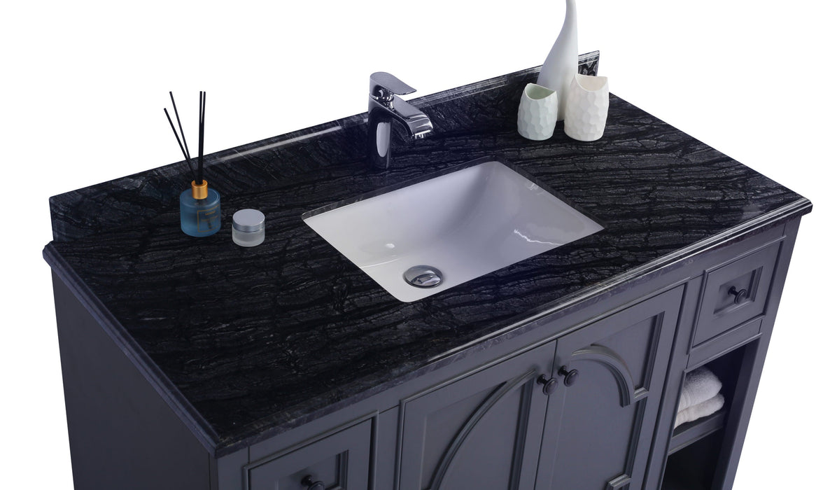 Bathroom vanity with a black marble countertop and white sink.