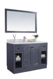 Bathroom vanity with mirror, gray cabinet, marble top.
