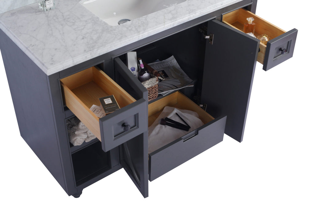 Open gray vanity with marble top, wooden drawers, and various toiletries.