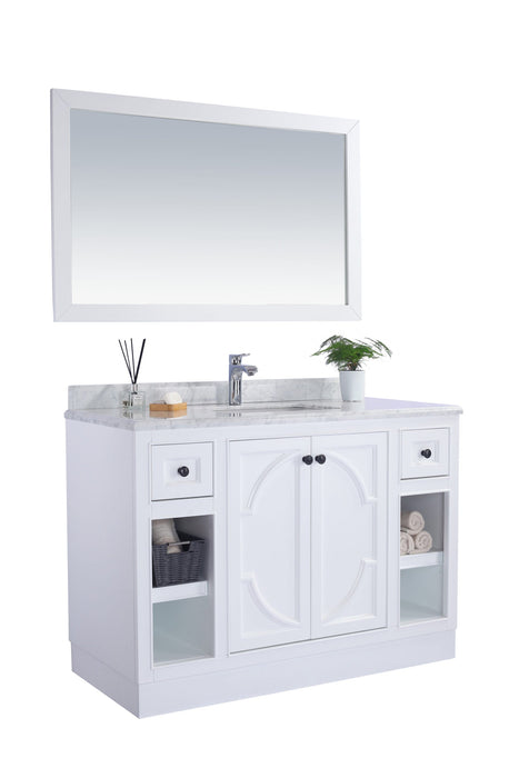 White bathroom vanity with a rectangular mirror, marble countertop, and dark hardware.
