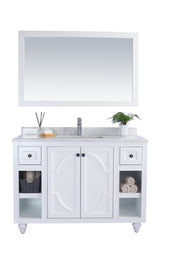White bathroom vanity with marble countertop and mirror.