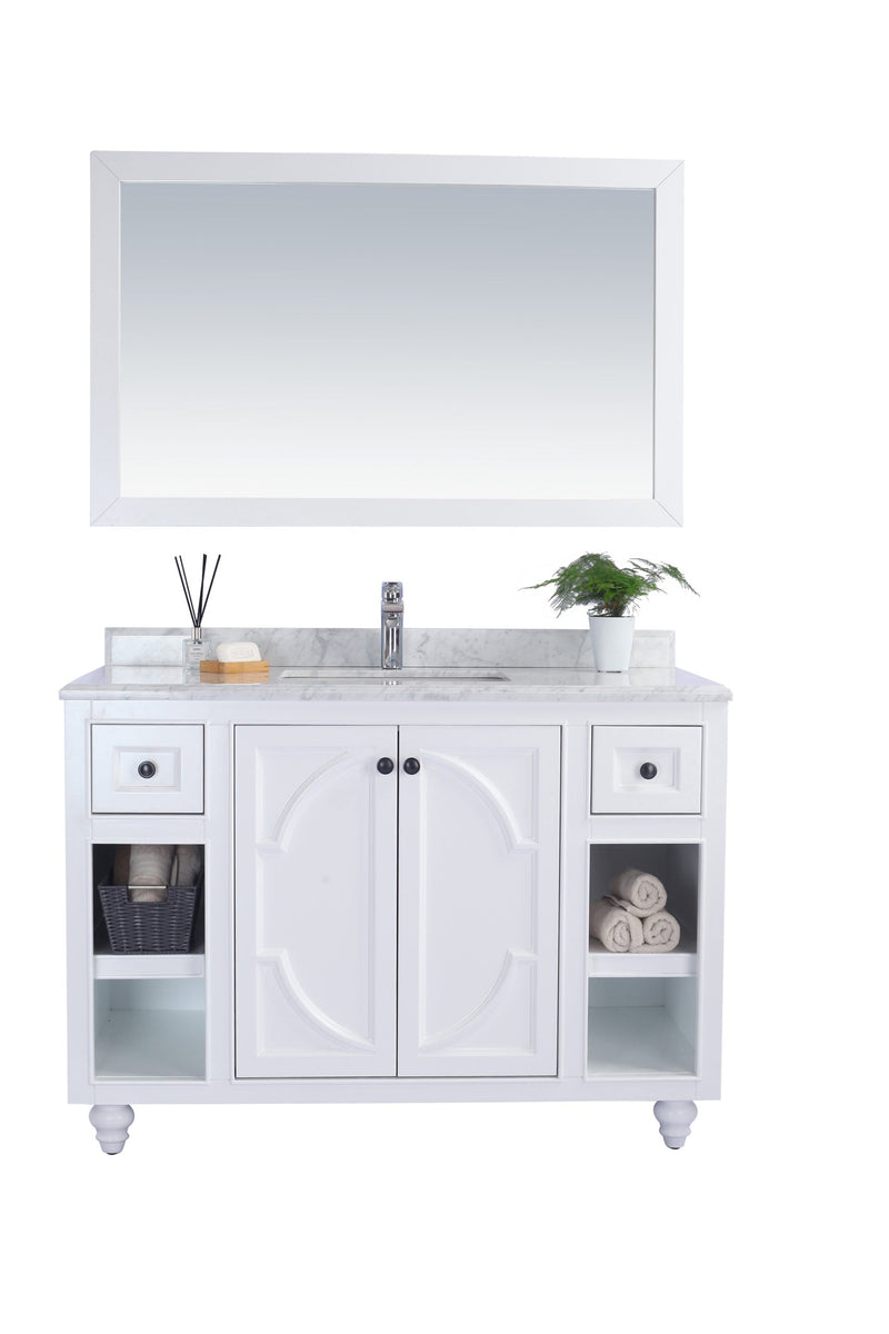 White bathroom vanity with marble countertop and mirror.