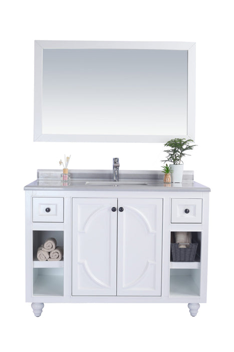 White bathroom vanity with a rectangular mirror, marble countertop, and storage shelves.