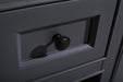 Close-up of a grey wooden drawer with a dark brown round knob.
