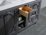 Gray bathroom vanity with marble top, opened drawer, and open shelf.