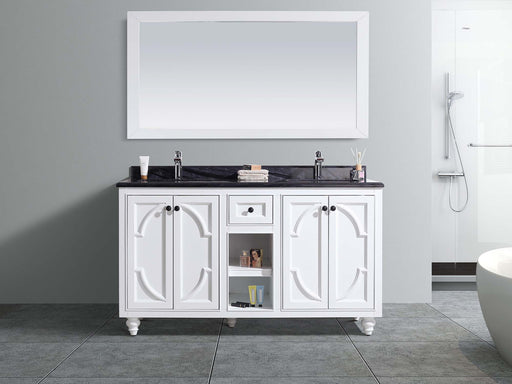 White bathroom vanity with black countertop and white framed mirror.