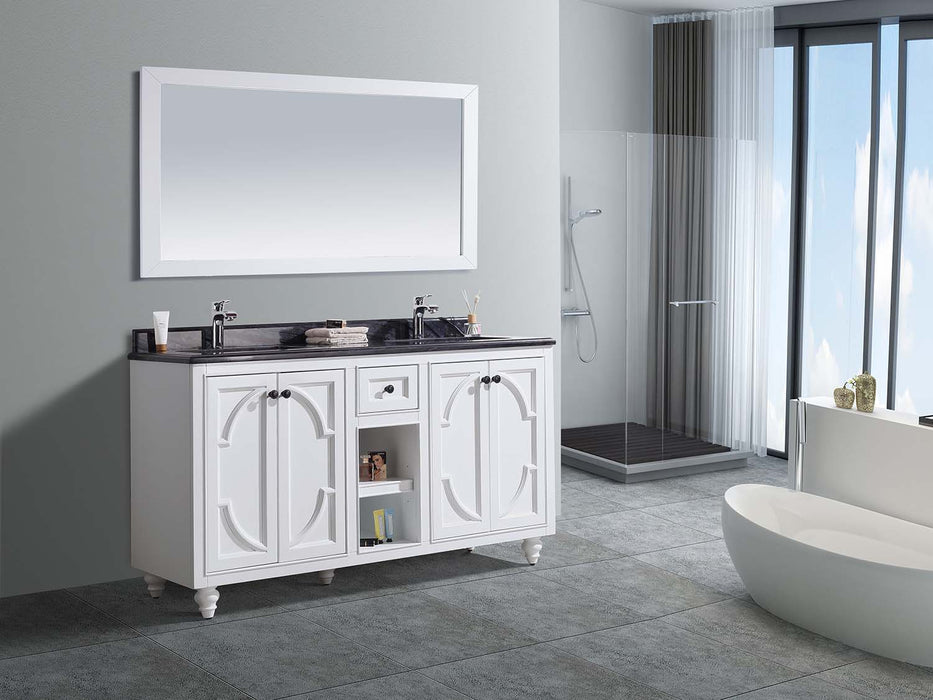 White bathroom vanity with black countertop, white framed mirror, standalone tub, and glass shower.
