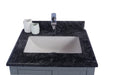 Bathroom vanity with black marble countertop, white sink, and silver faucet.