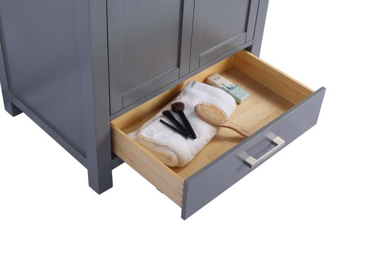 Gray vanity with open drawer containing makeup brushes, a hairbrush, and a white towel.