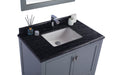 Bathroom vanity with dark countertop, white sink, and gray cabinet. A mirror is partially visible at the top.