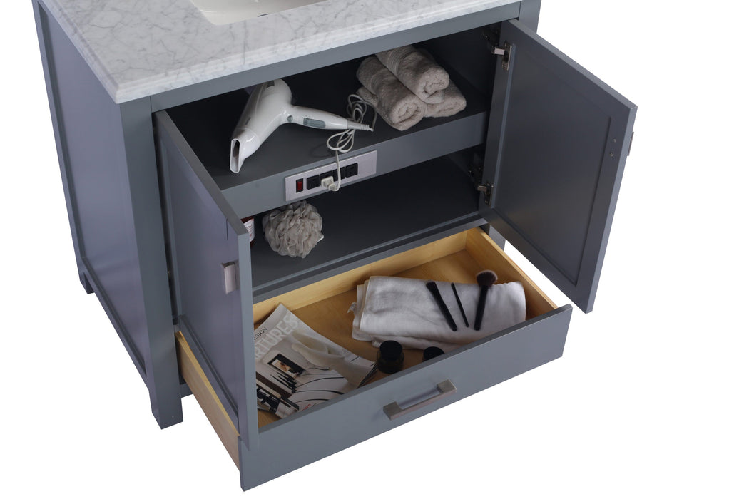 Gray bathroom vanity with white marble top, open cabinet, and partially open drawer.