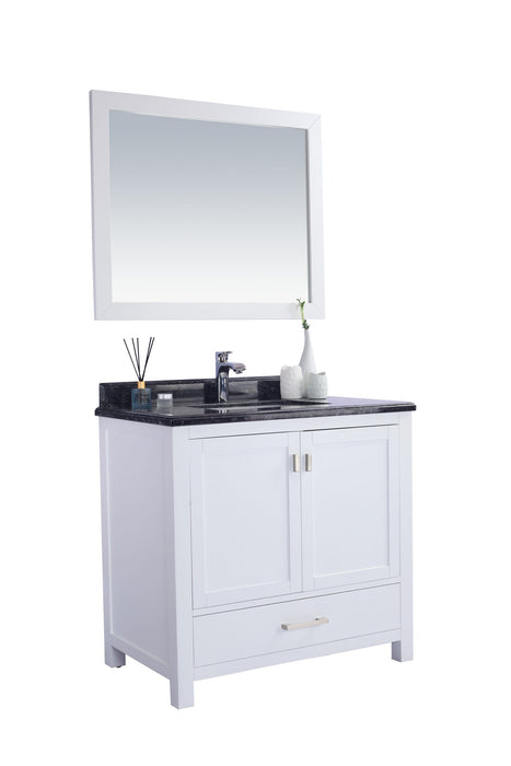 White bathroom vanity with black countertop and mirror.