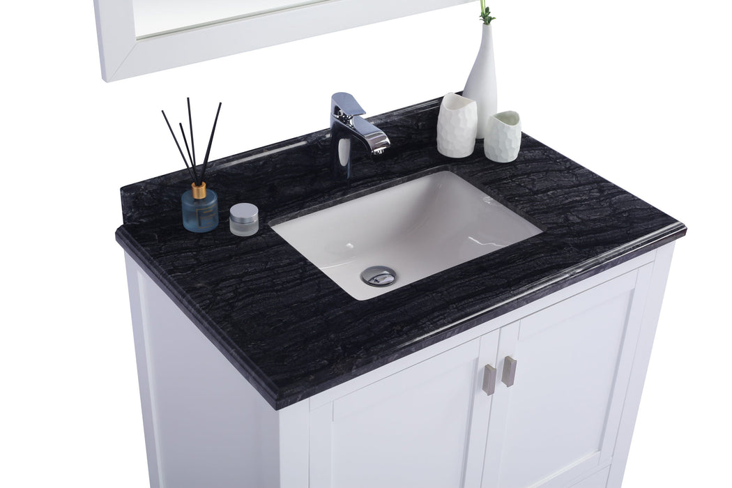Bathroom vanity with dark granite countertop and white cabinet.