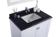 Bathroom vanity with dark granite countertop and white cabinet.