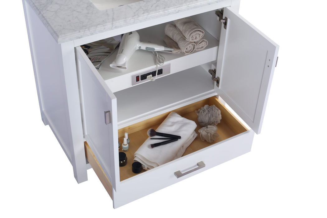 Open white bathroom vanity with marble countertop, towels, hair dryer, toiletries, and drawer.