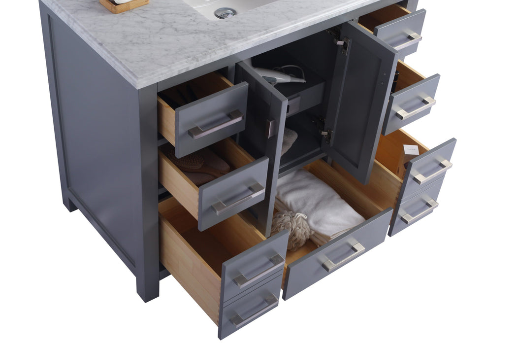 Bathroom vanity with open gray doors and drawers.