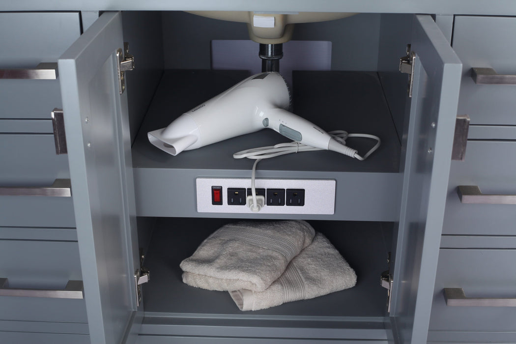 Gray bathroom vanity with a white hair dryer and towels inside an open cabinet door.