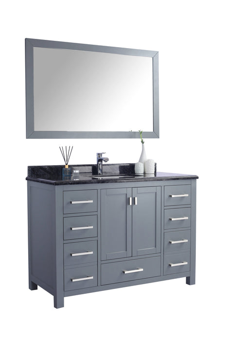 A gray bathroom vanity with a black countertop and a matching mirror.