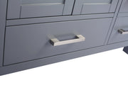 Close-up of gray cabinet doors and drawers with brushed metal handles.
