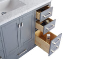 Gray bathroom vanity with marble top and open drawers.