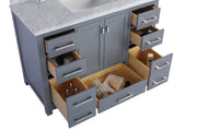 Gray bathroom vanity with marble top and open drawers revealing contents.