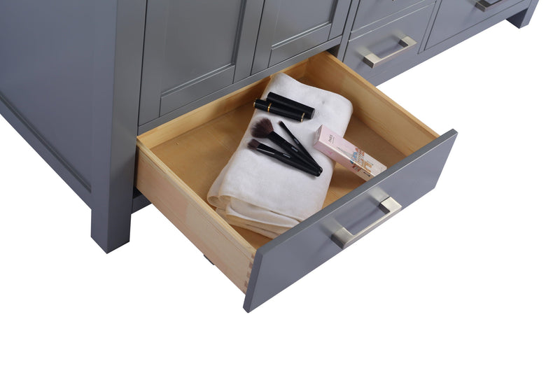 Close up of a gray vanity with an open drawer containing makeup, brushes and a white towel.