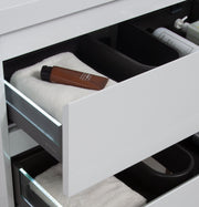 Open white bathroom drawer with brown tube and toiletries.