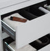 Open white bathroom drawer with brown tube and toiletries.