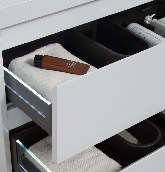 White vanity with open drawers, showing towels and toiletries.